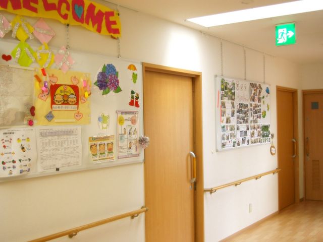 明るい廊下の風景 廊下 装飾が施された廊下は、訪れる方々を暖かく迎えてくれる空間です。手摺りが整備され、安全に配慮された設計となっています。