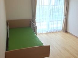 明るい居室のベッドと窓