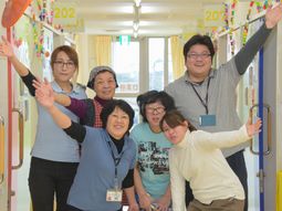 スタッフが笑顔で手を振る廊下