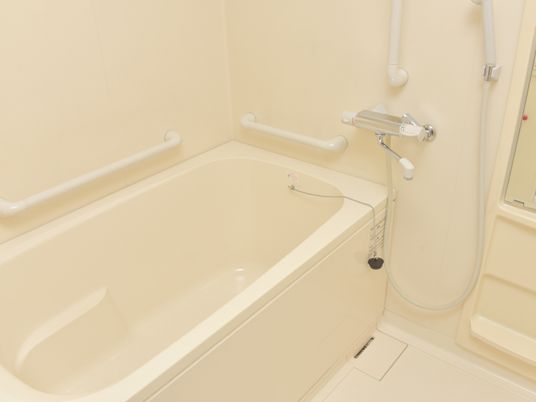 浴室は、白でまとめられた爽やかなデザインになっている。周囲の壁には頑丈な手すりが設置されていて、安心して入浴できる。