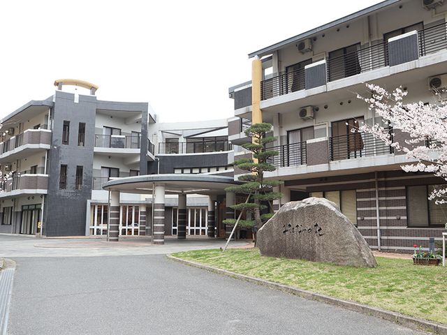 桜の咲く外観 外観 桜が咲く時期に撮影された建物で、明るいエントランスが印象的です。施設の駐車場も広々としています。