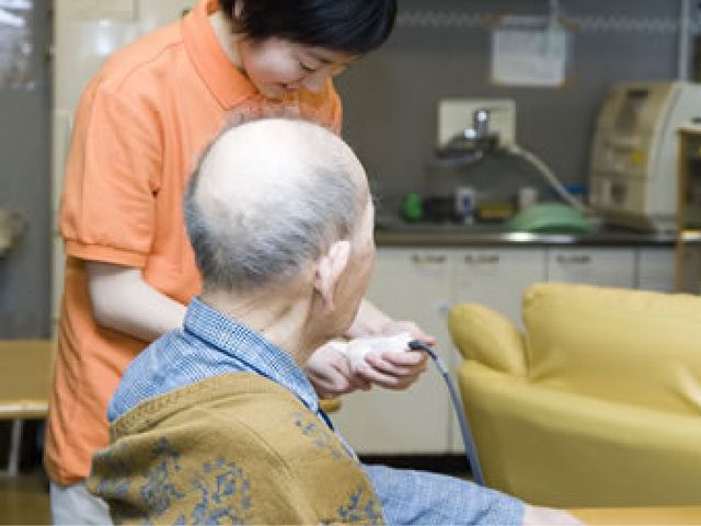 リビングのアクティビティ リビング 日常の活動が行われる明るい空間で、心地よい交流が可能です。スタッフが利用者を支えています。