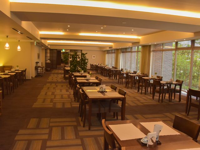 広々とした明るい食堂 ダイニング ゆとりある空間のダイニングで、利用者さまは毎食のひとときをお過ごしいただけます。窓の外の緑が心地よい光を室内に届けています。