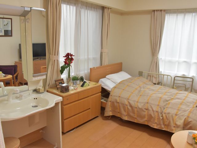 明るい居室の紹介 部屋 ゆとりのある居室は、必要な家具が整い、明るい窓から日差しが差し込む心安らぐ空間です。毎日を快適に過ごすための配慮が感じられます。