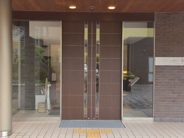 入口の自動ドア エントランス 自動扉のエントランスは、迎える暖かさと開放感を兼ね備え、訪れる方を穏やかに出迎えています。