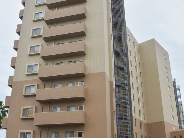 高層の建物外観 外観 落ち着いた色合いのモダンな建物です。窓が多く、明るさと快適さを感じさせる設計になっています。