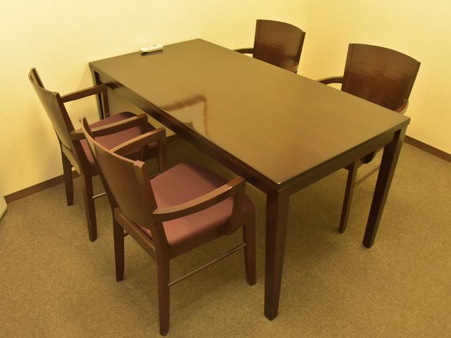 居室のテーブルと椅子 相談室 木製のテーブルと椅子が配置された落ち着いた雰囲気の居室です。心地よいくつろぎの時間を過ごすことができます。