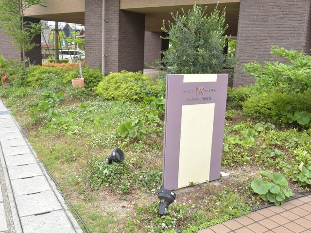 中庭の緑あふれる看板 看板 自然に囲まれた看板が訪問者を暖かく迎えてくれます。緑豊かな環境での勤勉は、癒しの時間をもたらすでしょう。