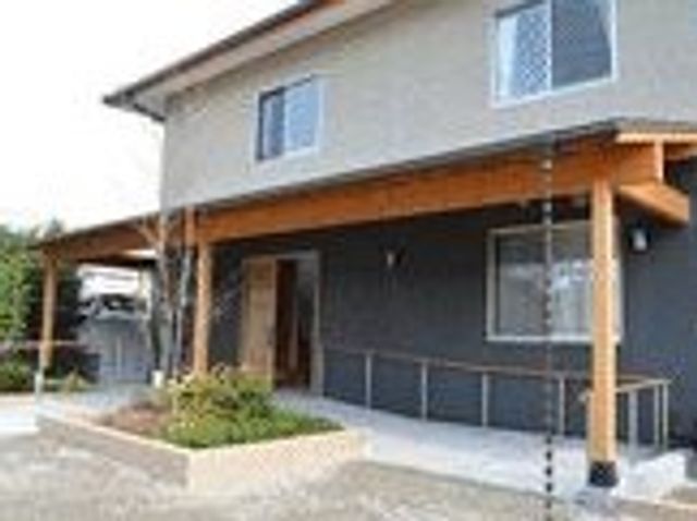 木目調の暖かい外観 外観 自然な色合いの外観が落ち着いた雰囲気を醸し出し、訪れる方々を温かく迎えます。清潔感のある入り口はスタッフと訪問者のコミュニケーションにも最適です。