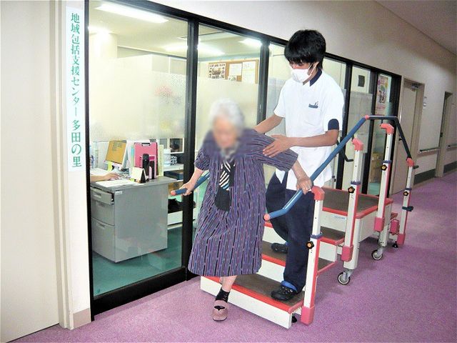 トレーニング中の階段 機能訓練室 階段を使ったリハビリが行える施設です。スタッフが安心してサポートします。