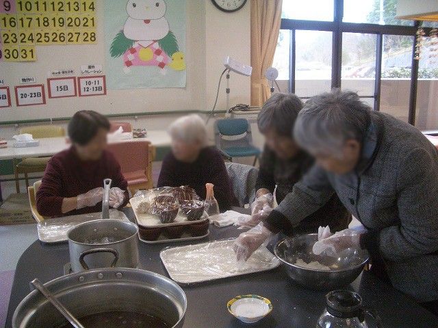 お料理の風景 ラウンジ みなさんが集まり、楽しそうに食事の準備を進めています。温かみのある雰囲気が特徴です。