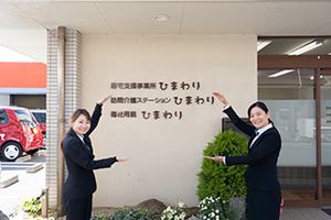 笑顔で案内する人々の看板付近