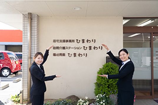 笑顔で案内する人々の看板付近