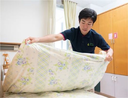ベッドメイキングする居室