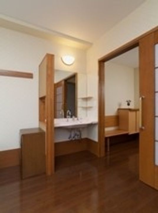 居室の中にある洗面台とドアを写した写真。ワンルームタイプの部屋に設備が置いてある様子