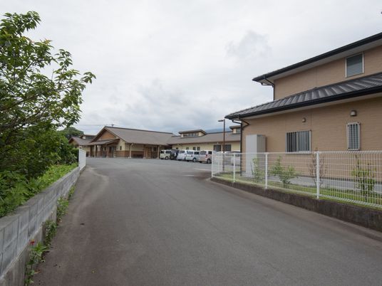 茶色い屋根の建物と駐車場