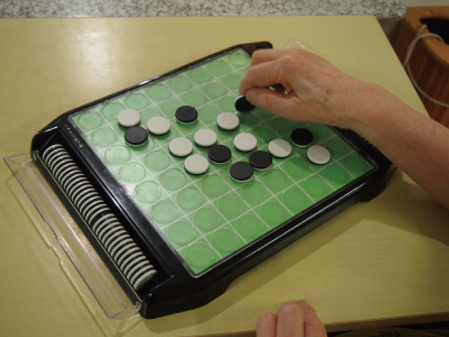 ゲームを楽しむ手元 スタッフイメージ シンプルなボードゲームを楽しむ手の様子です。リラックスした時間の共有が可能です。