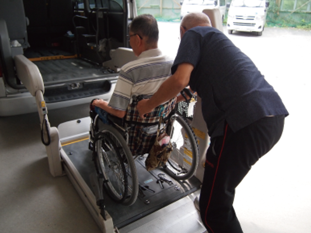 車椅子の乗降サポート場面 外観 利用者が安心して移動できるよう、スタッフが優しくサポートしています。