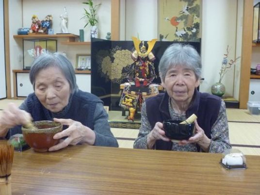 和室で茶を飲む高齢者二人