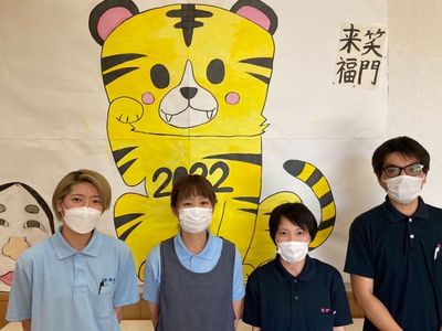 スタッフと壁画の前で