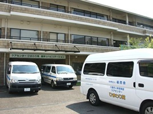 送迎車が並ぶ施設外観  