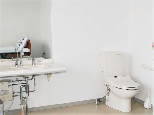 清潔なトイレと洗面台 トイレ 広々としたバリアフリー設計のトイレです。使いやすい洗面台と手すりが備わり、快適にご使用いただけます。