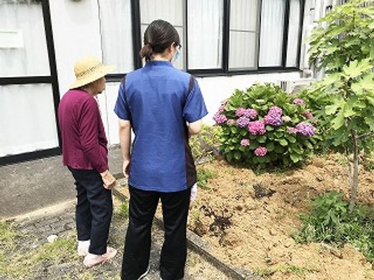 花壇を見るスタッフ