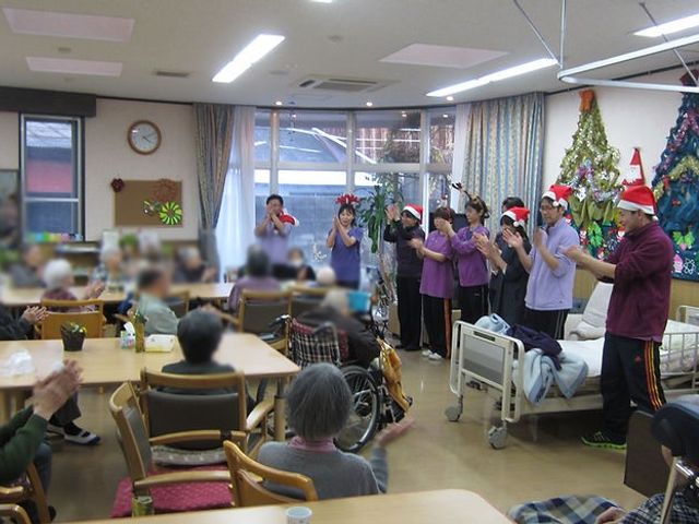 集まりが行われる空間 リビング 広々としたリビングで、スタッフと利用者が和やかに交流しています。明るい空間が印象的です。