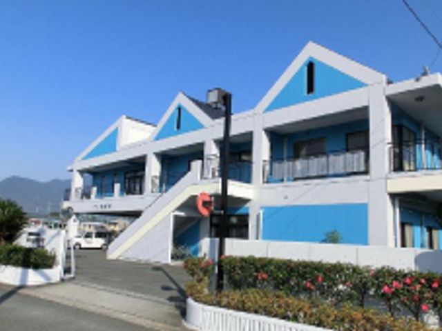 山を背にした建物の外観 外観 爽やかなブルーの外装が印象的な施設です。明るい環境で仕事を始めてみませんか。