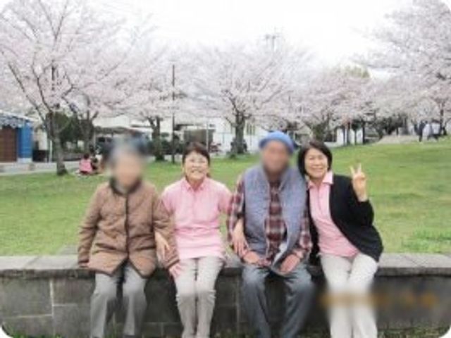 桜が満開の庭 庭 桜の木の下で、利用者とスタッフがリラックスして過ごしています。自然とのふれあいが楽しめる庭です。