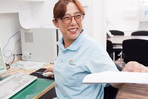 書類を手渡すスタッフ