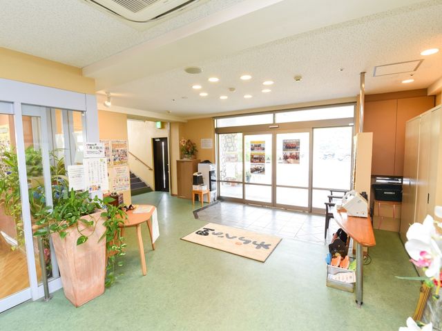 エントランスの明るい空間 エントランス 多彩な情報掲示物と観葉植物で迎える心温まるエントランスです。歓迎される空気感を、ぜひ一度感じてください。
