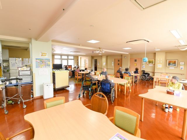 明るい共有ラウンジの様子 リビング ゆったりとした空間で、利用者がリラックスして過ごせるラウンジです。多様な椅子が配置され、コミュニケーションの場も提供しています。