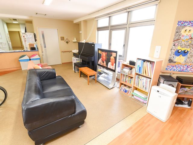 共有スペースの快適な居室 リビング ゆったりとしたソファが設置され、明るい光が差し込む快適なリビングです。利用者の方が日々の憩いの場として利用しています。