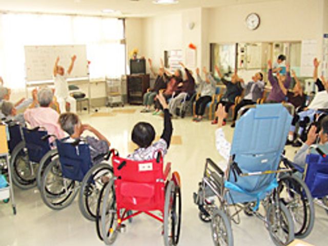 車椅子での体操風景 機能訓練室 車椅子を利用しながら参加できる体操セッションです。体を動かしながら楽しく交流ができます。