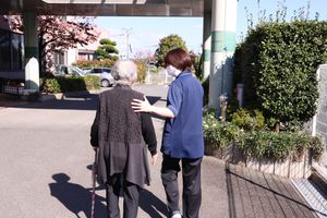 外で職員が歩行介助