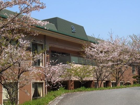 桜に囲まれた施設外観  