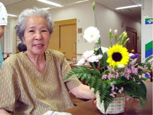 花と笑顔の高齢女性
