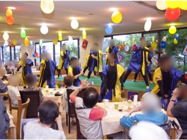 イベントが開催される食堂 イベント 色とりどりの飾り付けが施された食堂で、楽しそうなイベントが催されている様子が伝わります。見守る方々の笑顔からも温かい雰囲気が感じられます。