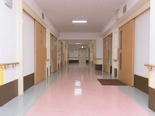 清潔感ある明るい廊下 通路 手すりが設置されており、ゆったりとした廊下は安全に配慮されています。手入れが行き届いており、快適な勤務環境が期待できます。