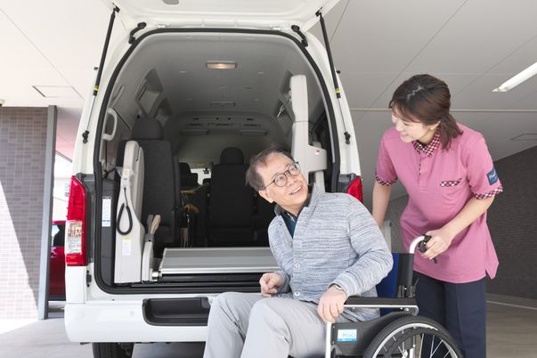 車いすの男性とスタッフの笑顔の場面