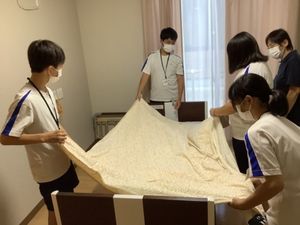 複数人でベッド整備中の居室