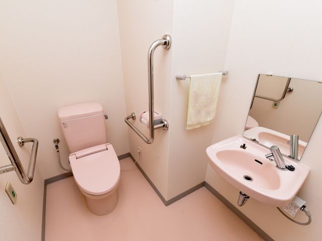 バリアフリートイレ設備 トイレ 手すりが設置された清潔感のあるトイレ空間です。日々の業務を通じて、安心の生活サポートを行うことができます。