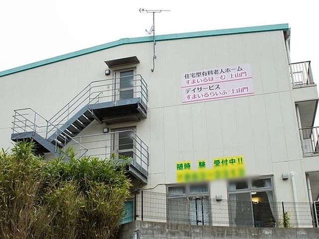階段付き外観 外観 建物の外には非常階段があり、緊急時にも安全に対応できる設計です。看板に施設情報が記載されています。