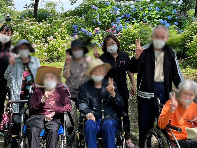 利用者とスタッフの庭 庭 スタッフと利用者が花に囲まれた場所で和やかに過ごしています。自然を感じながらリフレッシュする時間です。