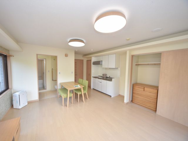 広々とした明るい居室 居室 広々とした居室には、リラックスできるダイニングテーブルとモダンなキッチンが整っており、快適な日常生活をサポートします。