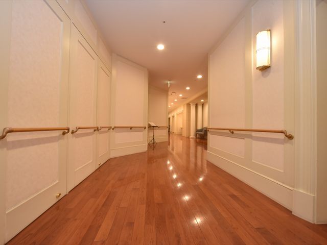 廊下の手すりと照明 通路 床から手すりに至るまで、ゆったりと設計された廊下です。安全と快適な移動のための配慮が感じられます。