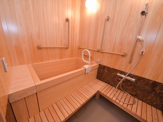 木目調の温かい浴室 居室 手すりが設置されているため、安全に配慮した入浴空間が整っています。木のぬくもりを感じさせるデザインで、リラックスできる時間をお過ごしいただけます。