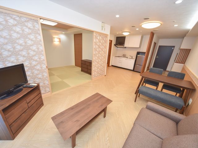 和室とキッチンのある居室 居室 和と洋が調和した居室です。木の温もりを感じる家具と清潔感のあるキッチンで、快適な生活を支えます。
