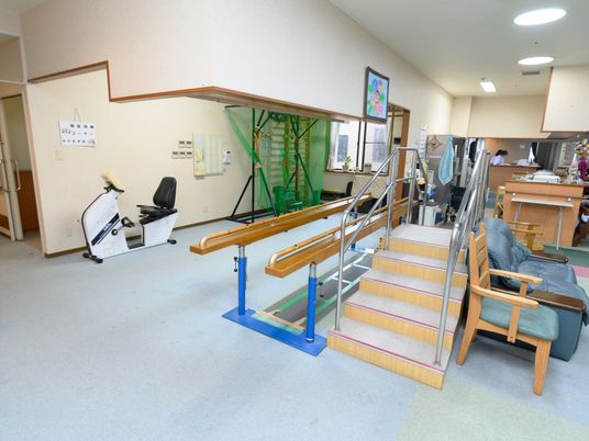 施設の写真 ホームの共有スペースにある運動器具である。ペダルをこぐ運動や階段の上り下り、平行棒を使った歩行訓練が行える。